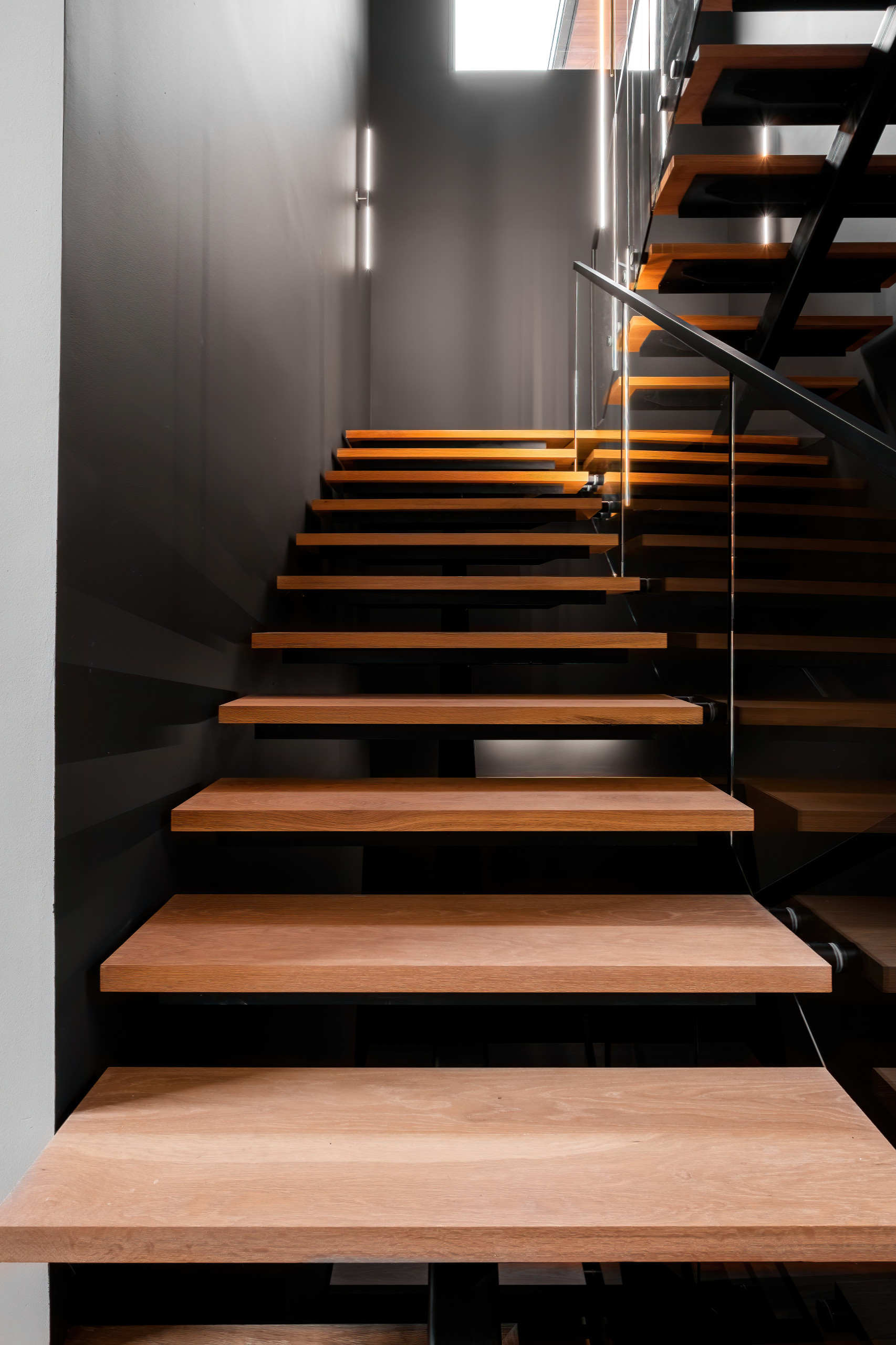 Modern metal staircase with glass railing by NG Metal Fabrication LLC
